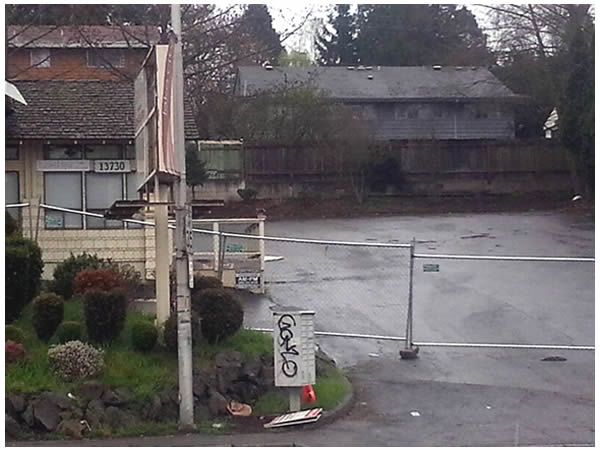 A rundown building and parking lot.